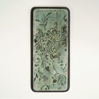 Wall art with green background and lace imprinted in on a white background