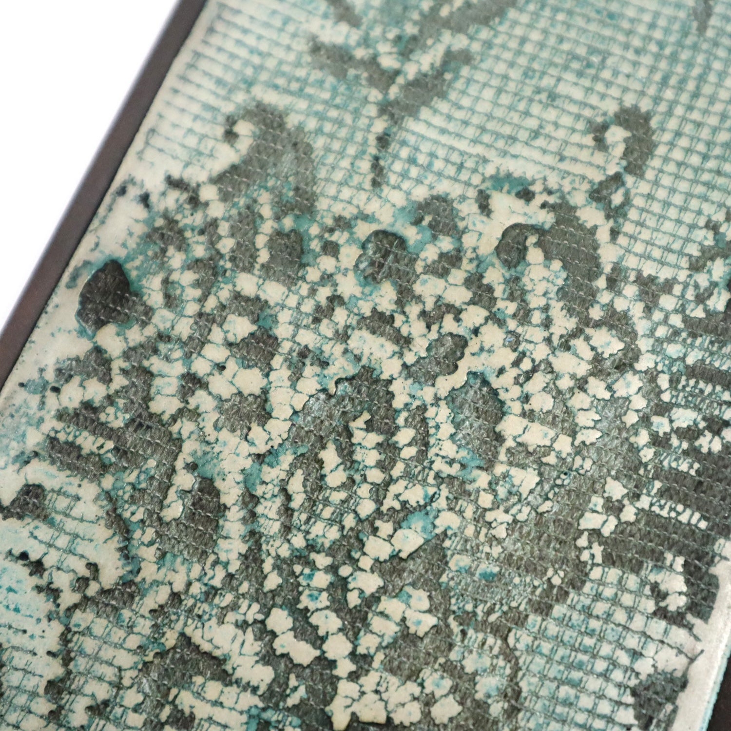Close-up of a textured wall art with a lace pattern pattern in green