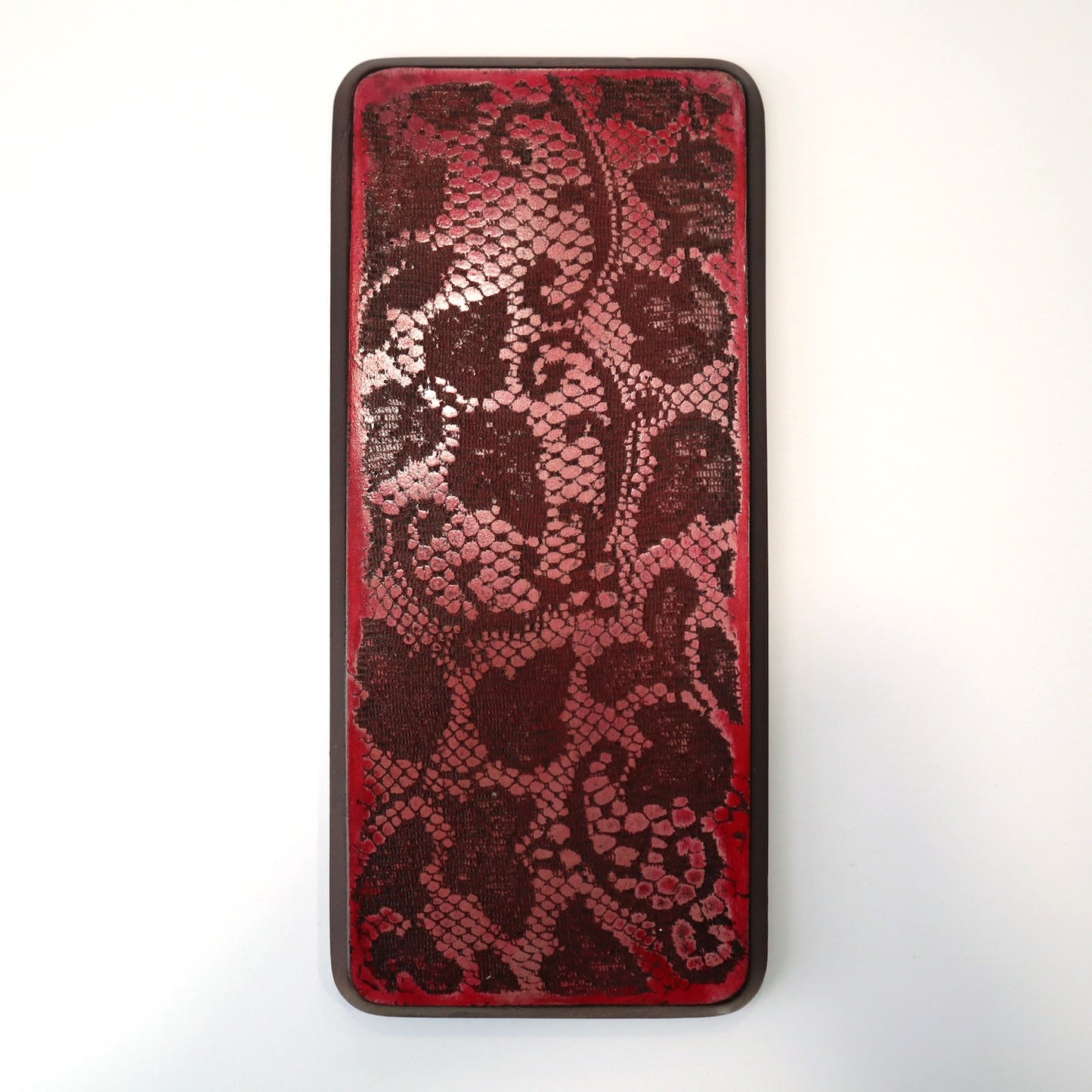 Red wall art with lace imprinted in