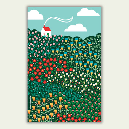 Hanging tea towel design with a bright meadow design and a white house with red roof in the top left corner