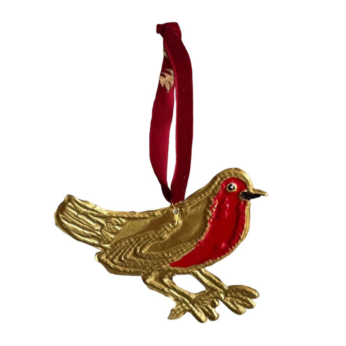 Handmade tin ornament in the shape of a robin hung with a red ribbon