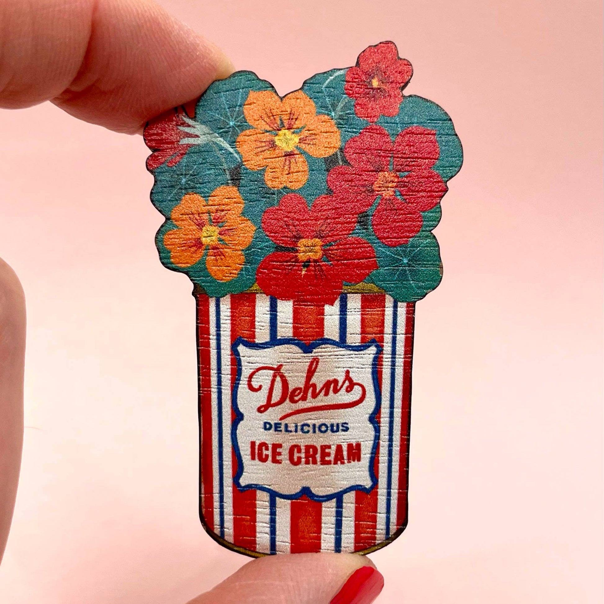 Decorative ice cream container with floral design and 'Dehn's Delicious Ice Cream' text on a pink background.