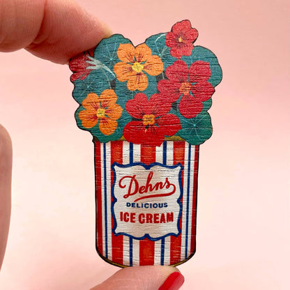 Decorative ice cream container with floral design and 'Dehn's Delicious Ice Cream' text on a pink background.