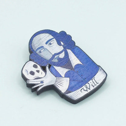 A wooden pin badge featuring William Shakespeare holding a skull