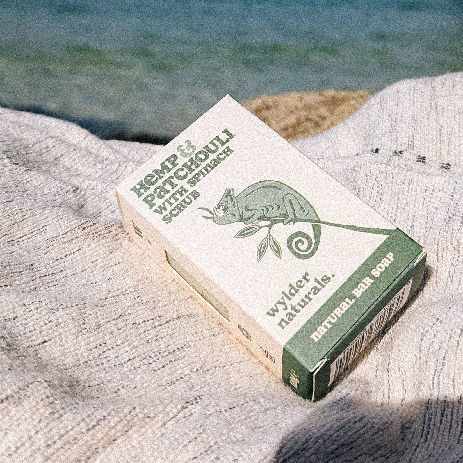 Box of bar soap laying on a grey lined by the side of the sea